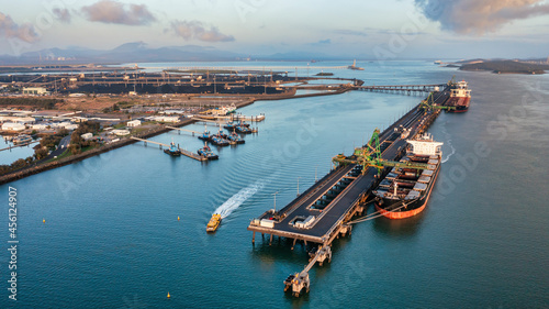 Aerial view of  coal ship and wharf with coal piles in the background