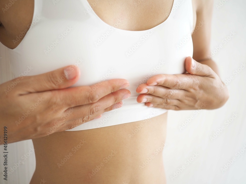 Fotka „Small breast problem a woman wearing exercise clothes or white  underwear. hands holding on chest. Breast augmentation concept. closeup  photo, blurred.“ ze služby Stock