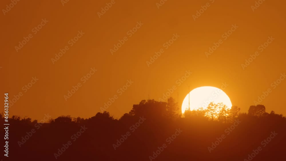 beautiful and colorful sunset timelaps the sun vanishing behind the trees in LA