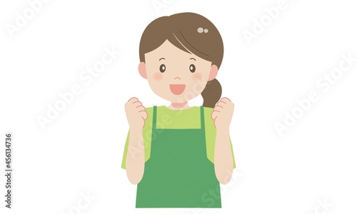 ガッツポーズをするエプロン姿の女性