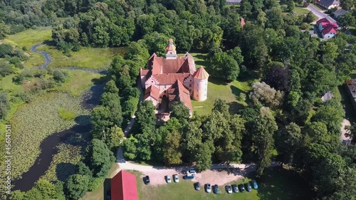 Aerial View of Edole Village, Edole Medieval Castle and Lake in Sunny Summer, Latvia, Courland (Kurzeme), Western Latvia. History, Architecture, Travel Destinations, National Landmark photo