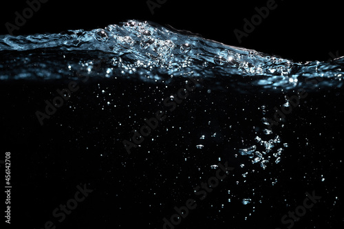 Water Surface with Ripple and Bubbles Float Up on Black Background.