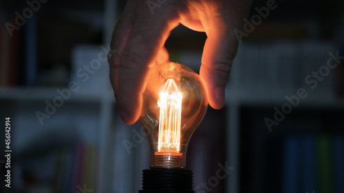 Fotografija Turning ON the Light in the Room, Screwing in the Socket an Incandescent Light Bulb