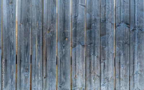 Texture of an old  darkened and cracked wood surface. Old rustic fence made of boards.