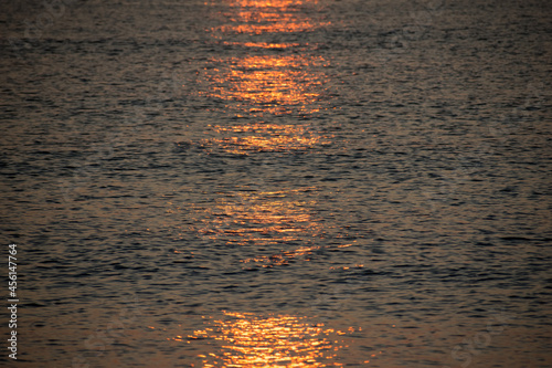 The reflection of the sun rising in the sea water. Texture.