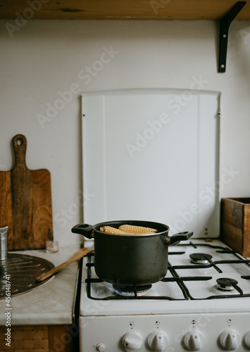 cooking the corn at the saucepan on the kitchen