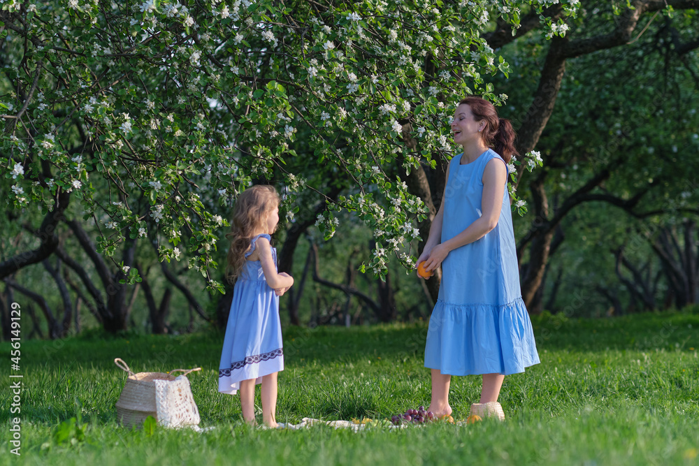 Fototapeta premium nature scene with family outdoor lifestyle. Mother and little daughter playing together in a park. Happy family concept. Happiness and harmony in family life.