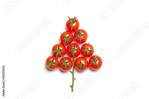 Christmas tree made of cherry tomatoes on a white background. Isolated background. Christmas decoration. Food tree. New year and Christmas. Seasonal holiday. Decoration of new year's window displays. 