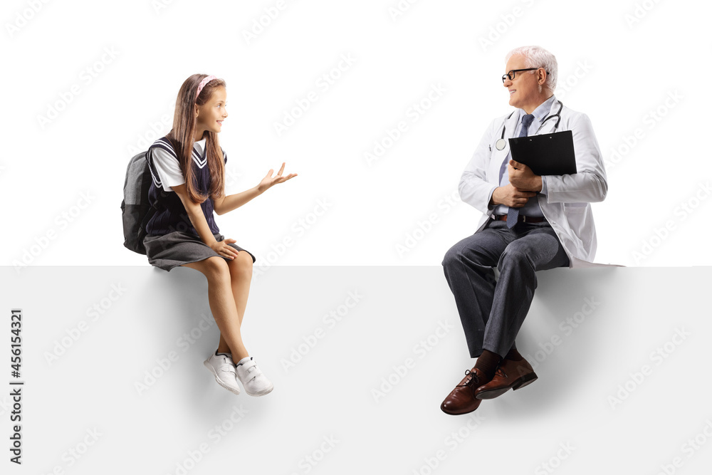 Schoolgirl sitting on a blank panel and talking to a mature male doctor Schoolgirl sitting on a blank panel and talking to a mature male doctor