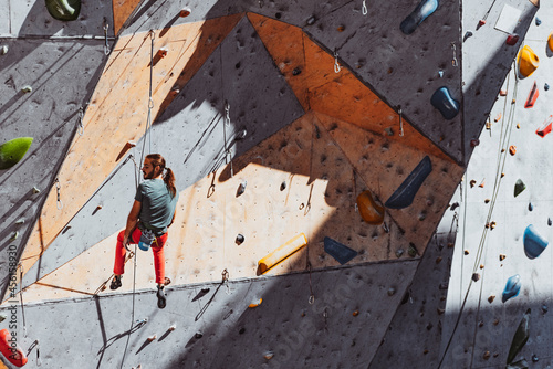 One Caucasian man professional rock climber practicing at training center in sunny day, outdoors. Concept of healthy lifestyle, tourism, nature, motion.