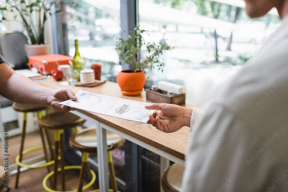 cropped view of waiter giving menu to client in cafe cropped view of waiter giving menu to client in cafe