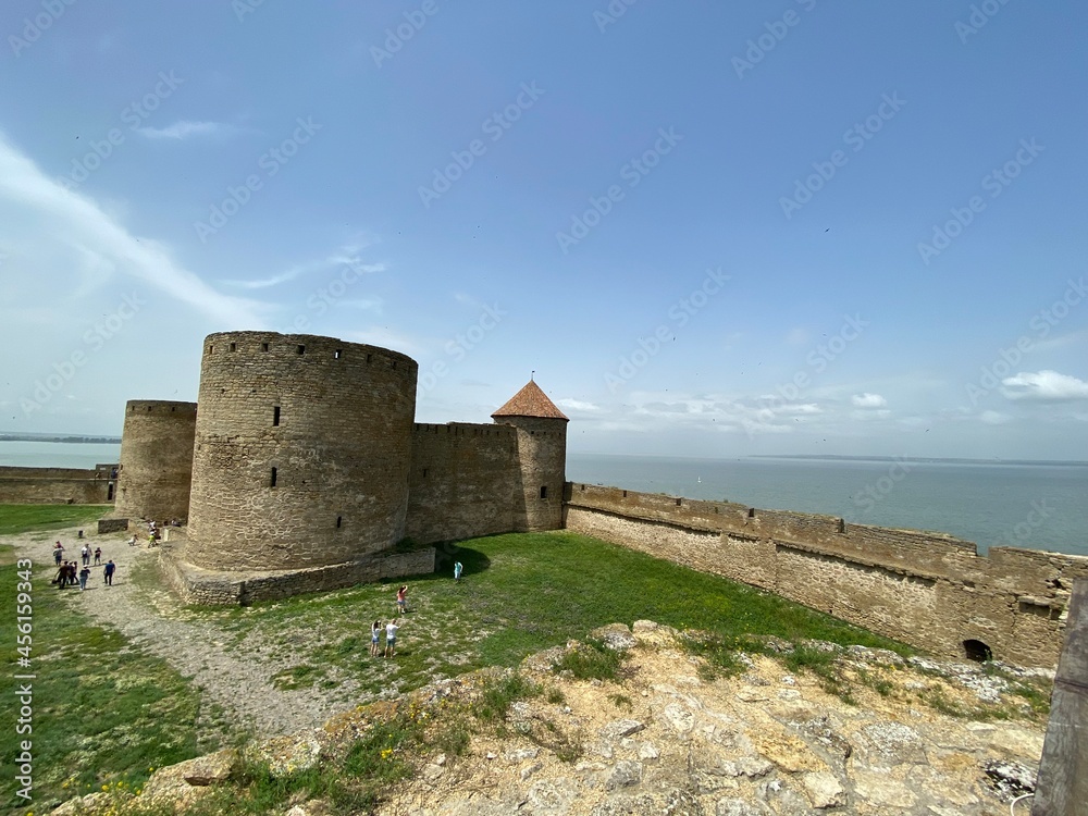 Top view of the strong walls of a medieval fortress against the backdrop of the boundless sea on the horizon. 