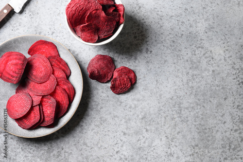 Process cooking vegetable beetroot chips on a gray background. Top view. Healthy vegan snack. Copy space.