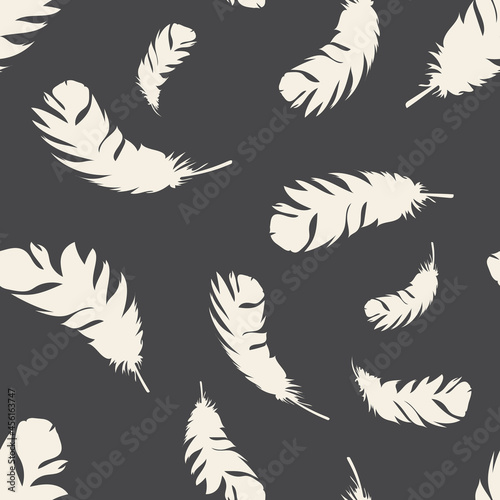 Bird light feathers fly on a dark background. Seamless pattern for modern fabrics, trendy textiles, decorative pillows. 