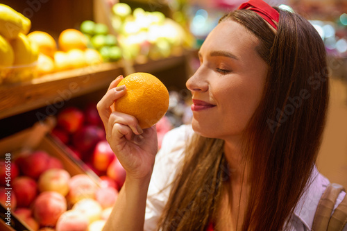 Foto A cute young woman in a fruits store