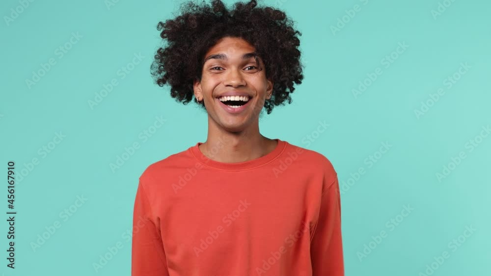 Surprised puzzled shocked young curly african american man 20s wears azure t-shirt shows mind explosion isolated on plain pastel light blue background studio portrait.People emotions lifestyle concept Surprised puzzled shocked young curly african american man 20s wears azure t-shirt shows mind explosion isolated on plain pastel light blue background studio portrait.People emotions lifestyle concept
