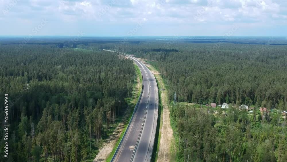 Construction of a high speed highway in the forest. Aerial video shooting from above from drone. Green trees. New asphalt pavement of the road. High quality FullHD footage Construction of a high speed highway in the forest. Aerial video shooting from above from drone. Green trees. New asphalt pavement of the road. High quality FullHD footage