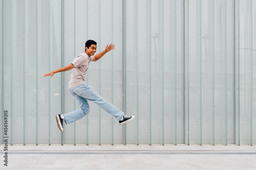 Young asian man outdoor jumping celebrating success feeling free