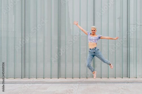 Fototapeta Naklejka Na Ścianę i Meble -  Young caucasian woman outdoor jumping celebrating success feeling free - advertising copyspace