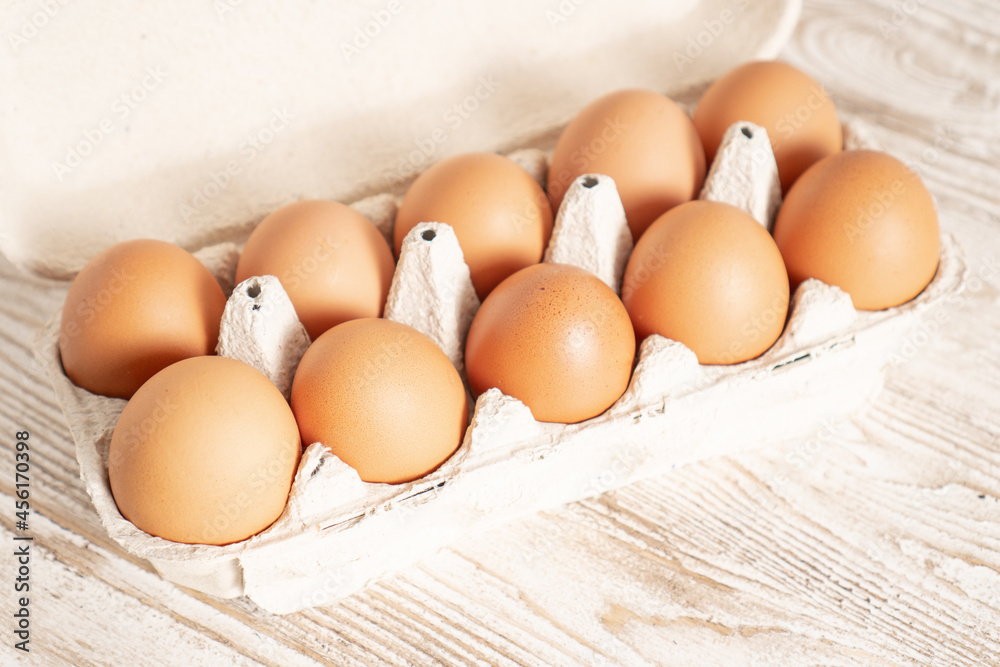 Eco eggs container. Raw chicken eggs in egg box. Cartons packing. Recycling concept. Cardboard egg rack with eggs Eco eggs container. Raw chicken eggs in egg box. Cartons packing. Recycling concept. Cardboard egg rack with eggs
