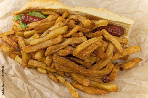 sandwich "américain", composé de saucisse, frites, et sauce dans une baguette de pain