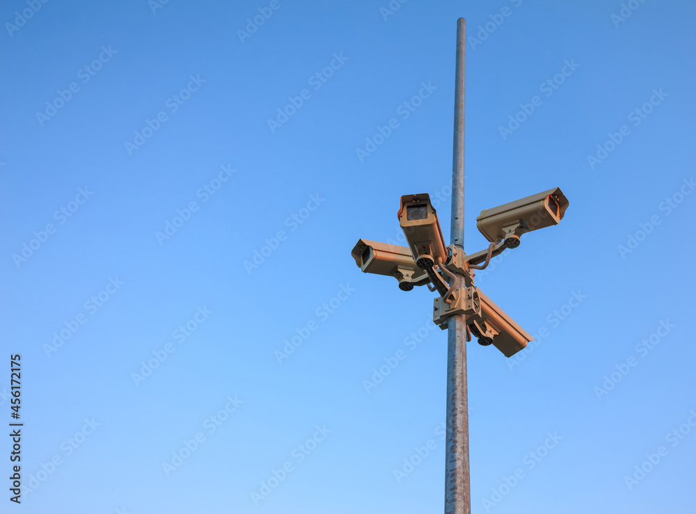 Column surveillance cameras on clear blue background, copy space Column surveillance cameras on clear blue background, copy space
