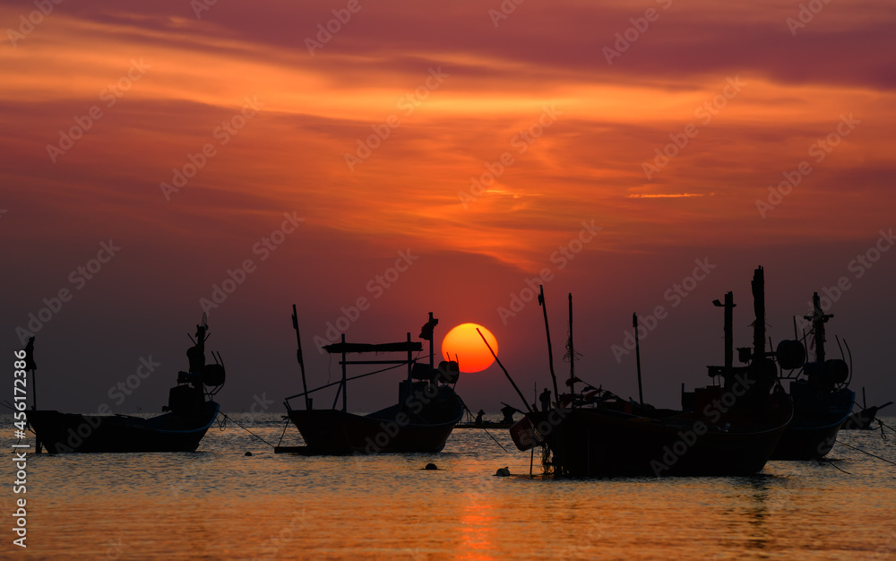 Silhouette Fishery wooden boat with sunset sky low lighting.