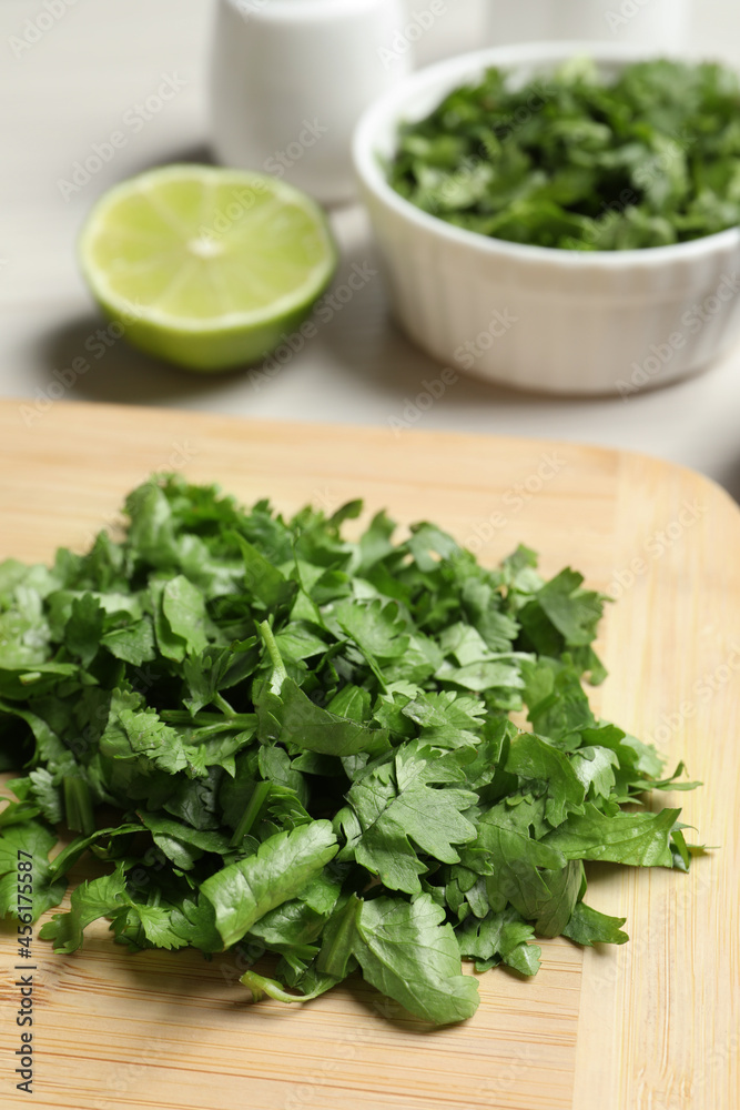 Raw green organic cilantro on wooden board, closeup Raw green organic cilantro on wooden board, closeup