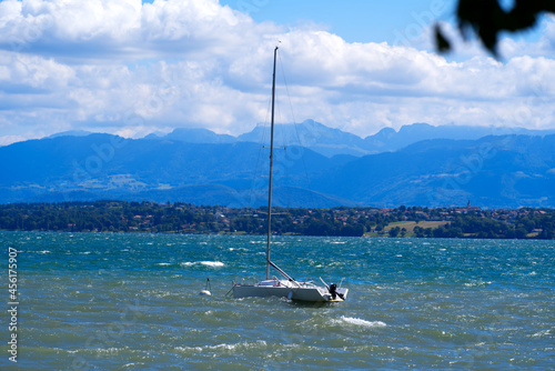Lake Geneva on a sunny and windy summer day with sailing boat and European Alps in the background. Photo taken August 28th, 2021, Nyon, Switzerland. © Michael Derrer Fuchs