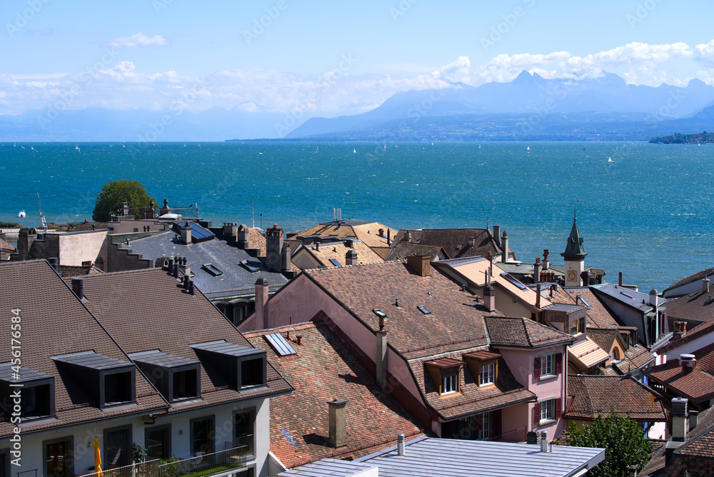 Beautiful view over the old town of Nyon with Lake Geneva and European Alps in the background on a sunny summer day. Photo taken August 28th, 2021, Nyon, Switzerland.