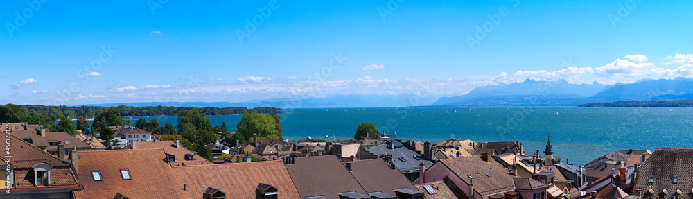 Beautiful wide angle view over the old town of Nyon with Lake Geneva and European Alps in the background on a sunny summer day. Photo taken August 28th, 2021, Nyon, Switzerland.