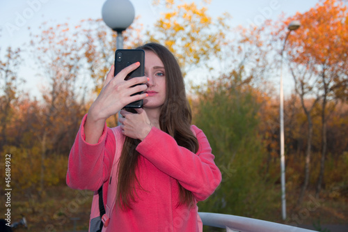 Pretty woman taking selfie in park in spring