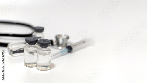 Panoramic banner. coronavirus vaccine bottle  stethoscope and medical equipment on white background  virus prevention  vaccination  medical technology  research laboratory  covid-19 vaccine concept