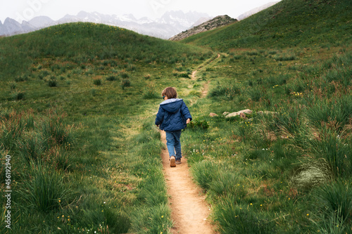 Little boy runnig on a path high  in the mountains. Hiking with children concept. photo