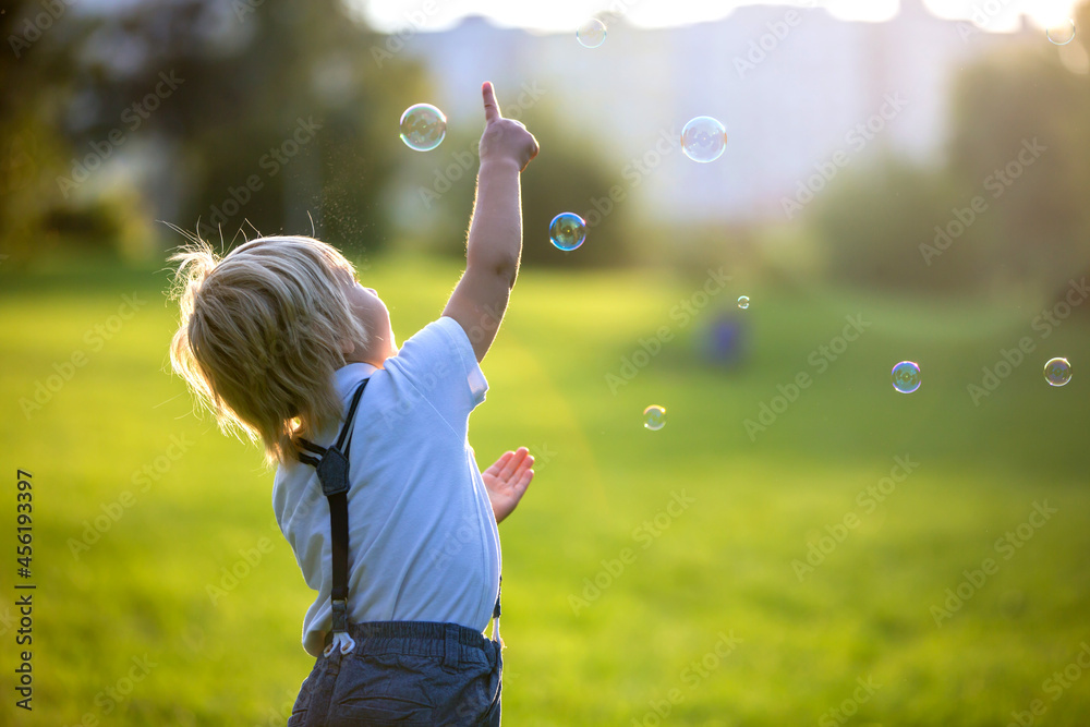 Cute preschool blond child, playing in the park on sunset, summertime Cute preschool blond child, playing in the park on sunset, summertime