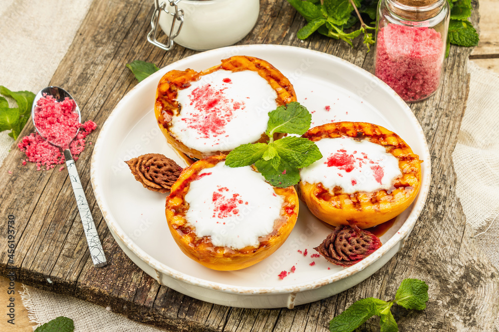 Grilled peach with yogurt, mint, and sweet pink sugar. Useful breakfast concept, healthy food