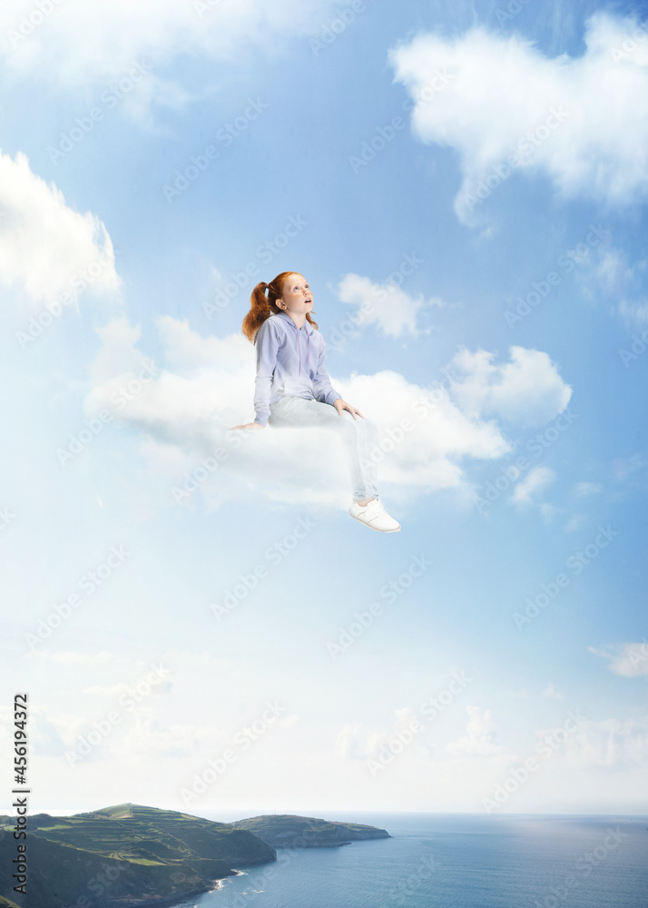 Conceptual collage with little beautiful girl sitting on white cloud and flying above sea, water, nature landscape. Concept of childhood, happiness, dreams Conceptual collage with little beautiful girl sitting on white cloud and flying above sea, water, nature landscape. Concept of childhood, happiness, dreams