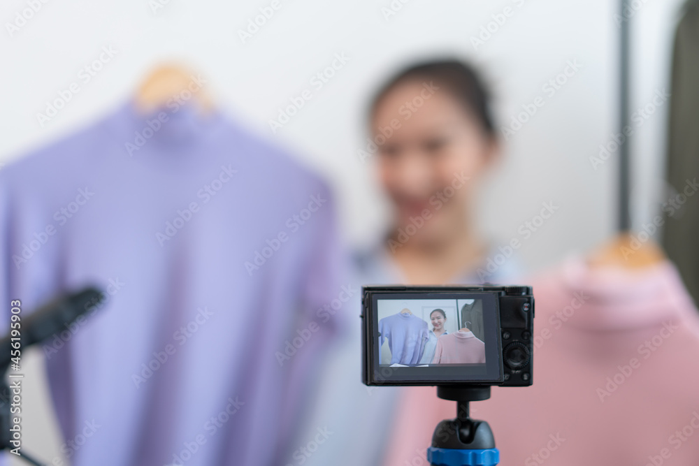 Live shopping concept a digital camera recording a video of a female seller and connecting with a device to broadcast a live shopping Live shopping concept a digital camera recording a video of a female seller and connecting with a device to broadcast a live shopping