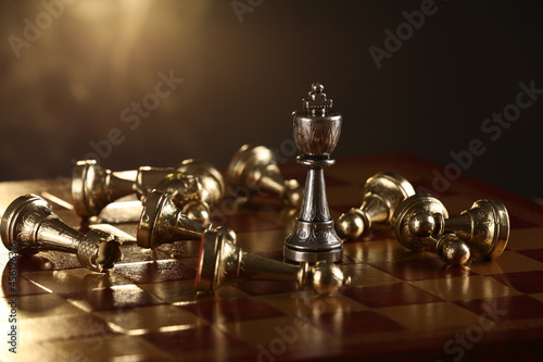 Chessboard with game pieces on dark background, closeup