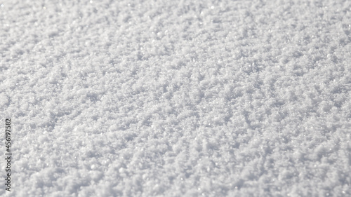 Natural snow texture. Smooth surface of clean fresh snow. Snowy ground. Winter background with snow patterns. Closeup top view.