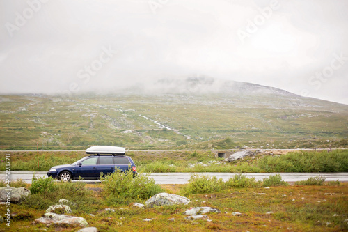 Family car with box on top, parked on a parking next to North arctic circle, where no trees and grass grow © Tomsickova