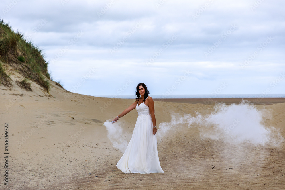 Glückliche junge Frau im Hochzeitskleid am Meer Glückliche junge Frau im Hochzeitskleid am Meer