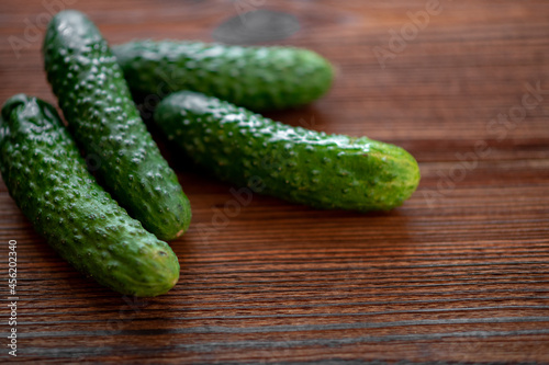 Fresh cucumbers on a dark wooden background.