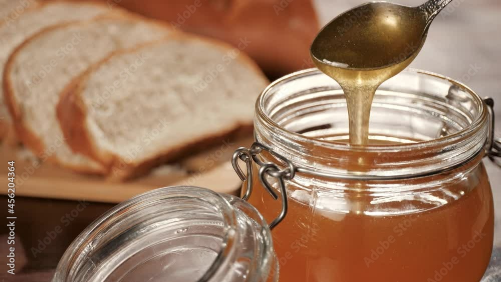 Honey. Honey pours out beautifully from teaspoon. Close-up and slow motion Honey. Honey pours out beautifully from teaspoon. Close-up and slow motion