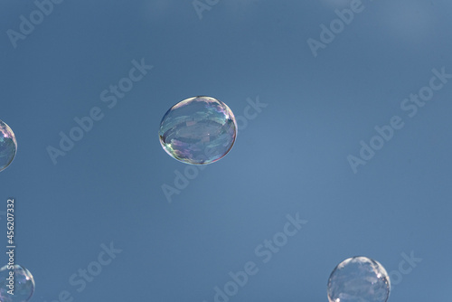 Soap bubbles on a blurred background. Lots of rainbow bubbles connecting with each other. The abstract background.