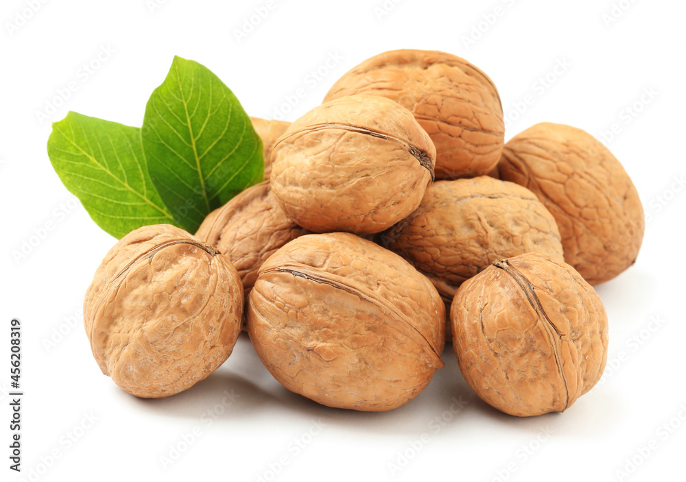 Whole walnuts in shell and leaves on white background Whole walnuts in shell and leaves on white background