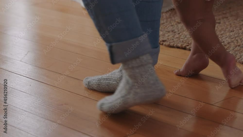 baby learning to walk toddler taking first steps with father helping infant teaching child at home baby learning to walk toddler taking first steps with father helping infant teaching child at home