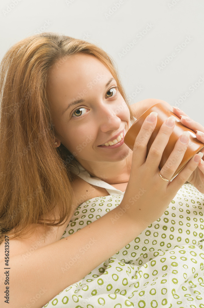 Woman in bed with cup of coffee