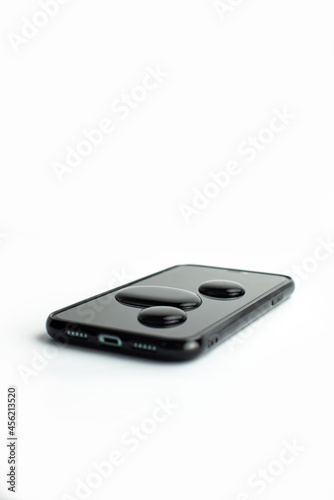 A wet black smartphone in white background