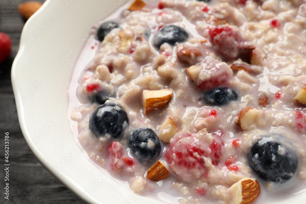 Tasty oatmeal porridge with toppings on table, closeup Tasty oatmeal porridge with toppings on table, closeup